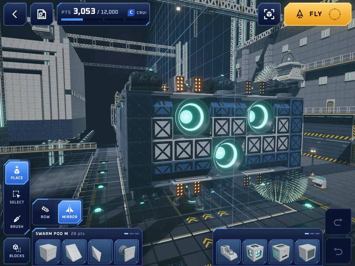Build mode: a blue ship with three glowing thrusters in the hangar, building tools on the left and a row of blocks along the bottom.